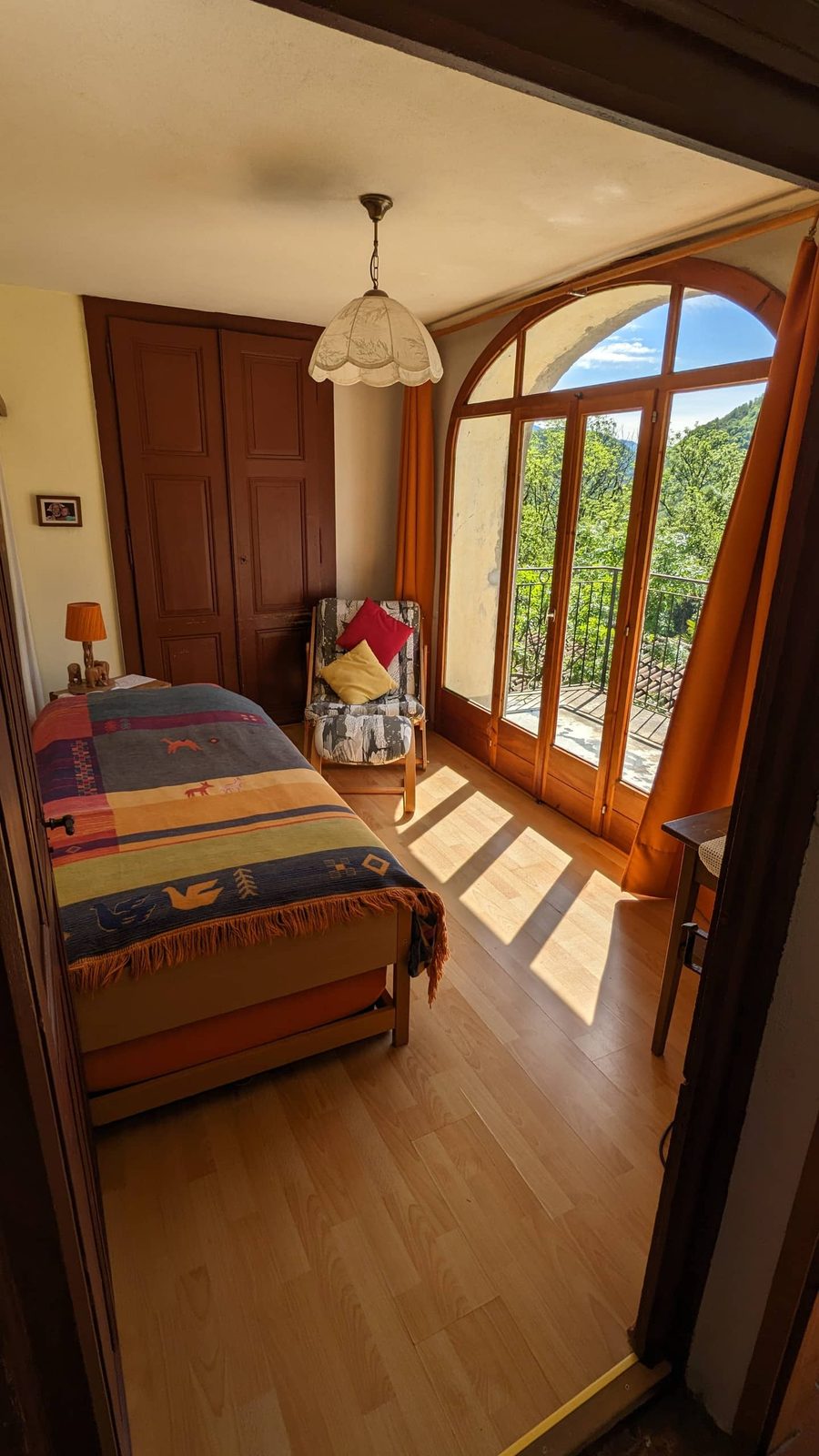 Sonniges Zimmer mit Bett und Balkontür