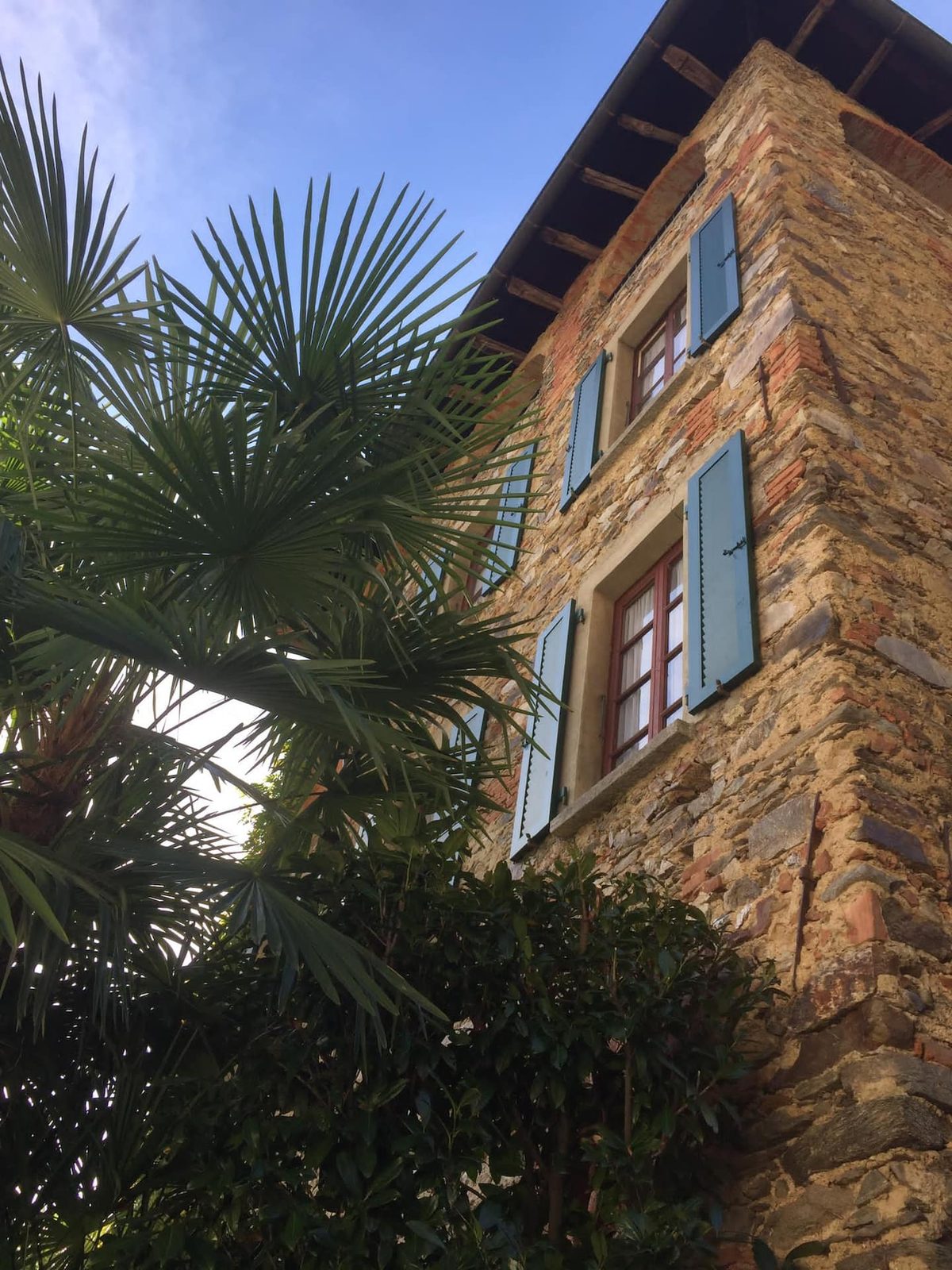 Steinfassade mit blauen Fensterläden