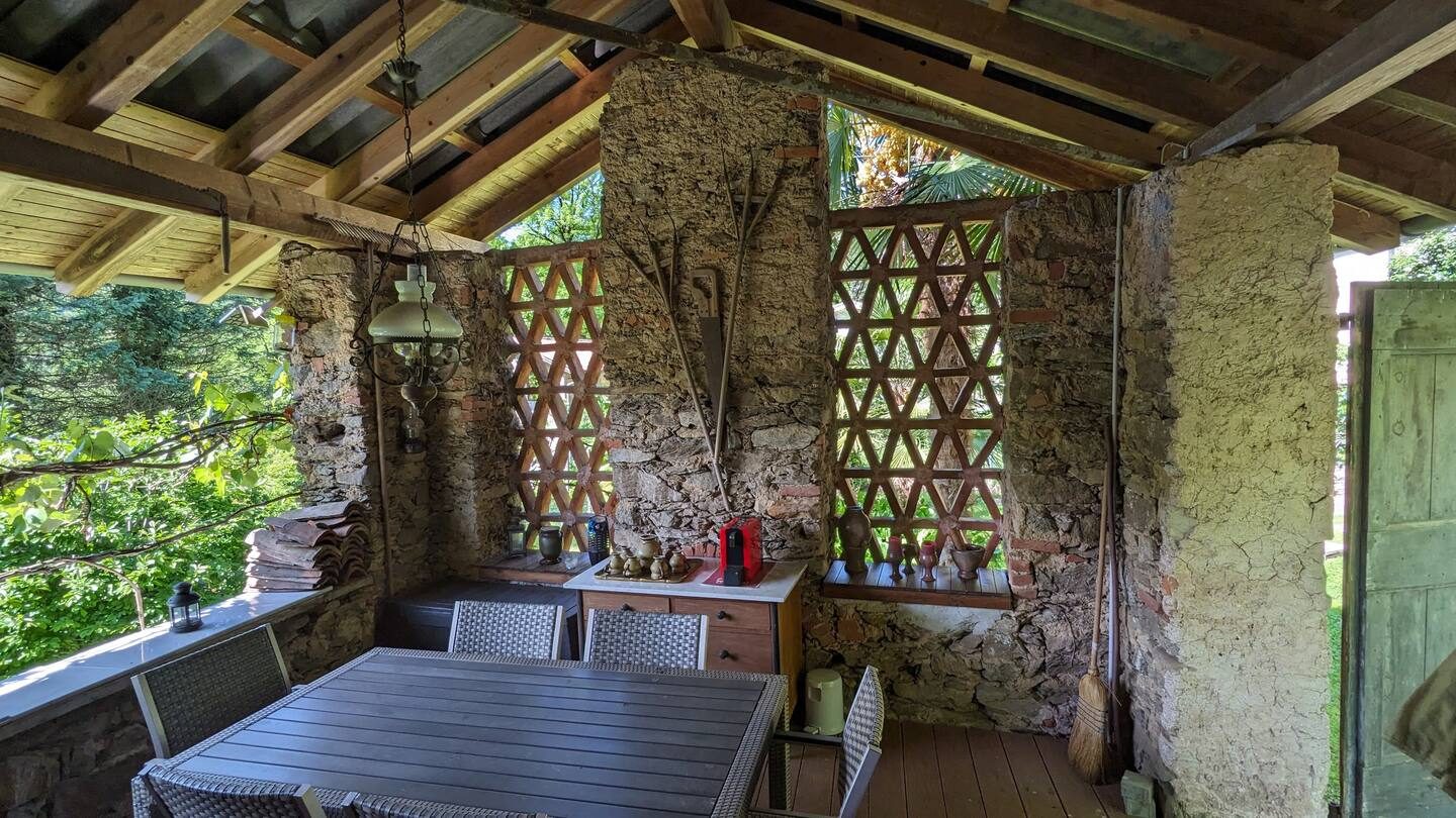 Rustikale Loggia aus Naturstein mit Sitzplatz